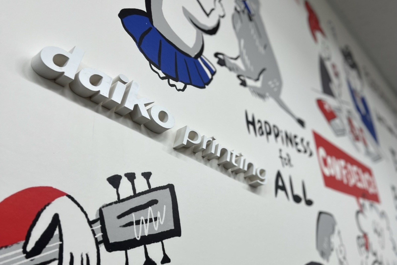 壁面アートに設置された「daiko printing」の立体(3D)ロゴサインのクローズアップ。背景に「HAPPINESS for ALL」「CONFIDENCE」の文字が見える。一般社団法人関西GX推進協議会 代表理事・GXアーティスト宇都宮涼子が制作した壁面アートの一部