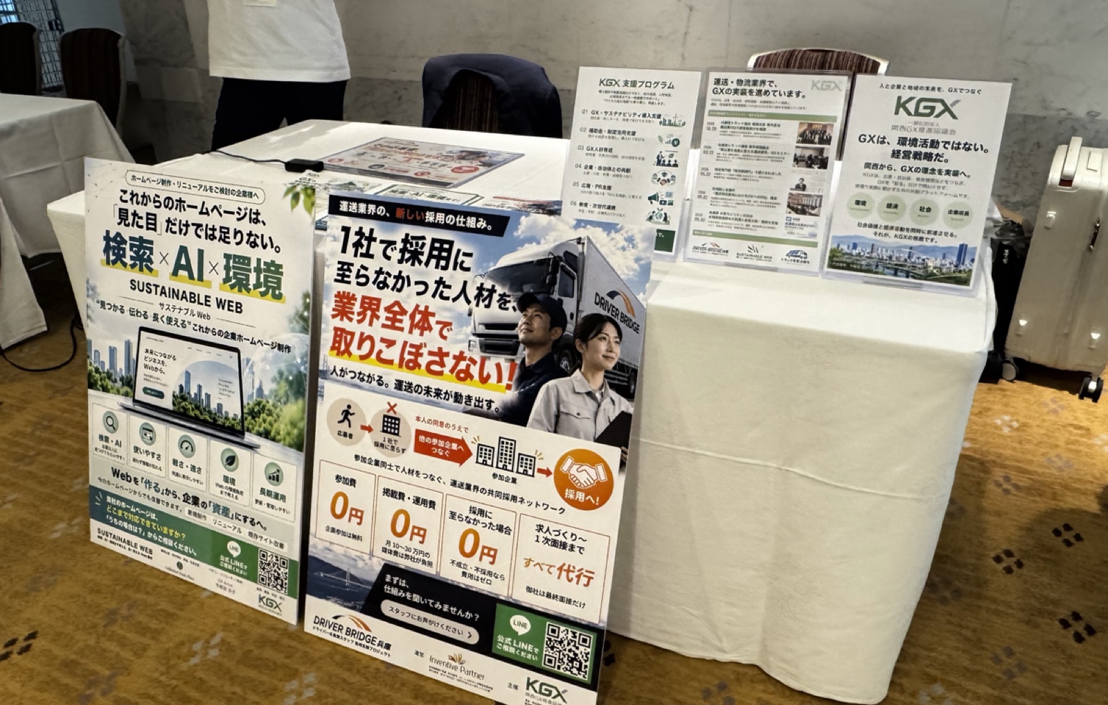 一般社団法人 関西GX推進協議会が令和8年度 全日本トラック協会青年部会 近畿ブロック大会に出展した協賛ブース。サステナブルウェブと採用支援ドライバーブリッジのパネルが並ぶ